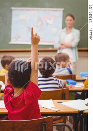Pupil raising hand during geography lesson in classrorm 13686434