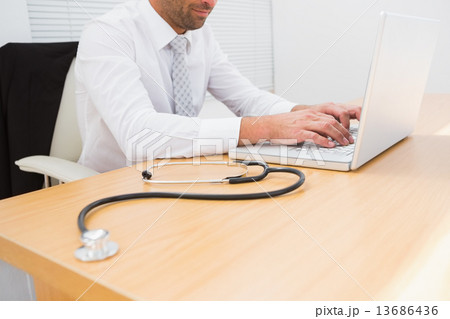 Businessman using his laptop Businessman using his laptop 13686436