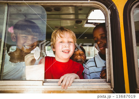 Cute pupils smiling at camera in the school bus 13687019
