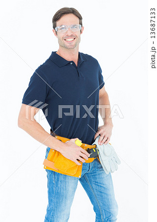 Confident man wearing tool belt over white background 13687133