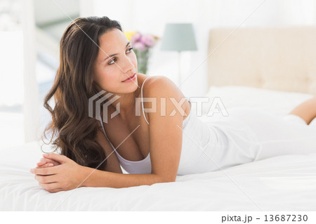 Happy brunette lying on bed Happy brunette lying on bed 13687230