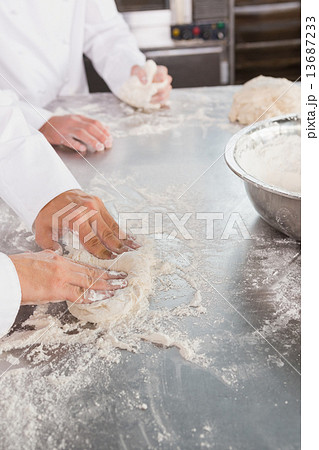 Close up of bakers kneading dough at counter 13687233