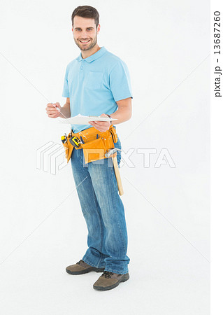 Smiling construction worker holding clipbard Smiling construction worker holding clipbard 13687260