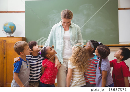 Cute pupils smiling at camera in classroom Cute pupils smiling at camera in classroom 13687371