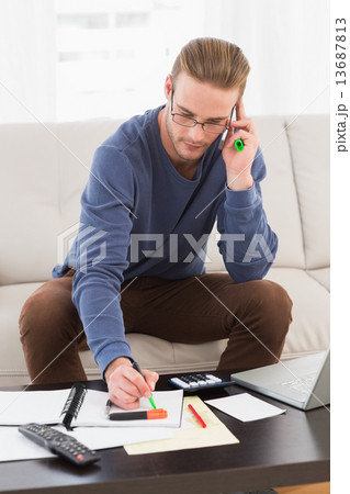 Concentrated man with glasses taking notes Concentrated man with glasses taking notes 13687813