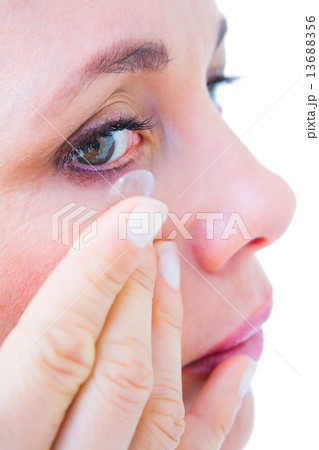 Close up of woman applying contact lens Close up of woman applying contact lens 13688356