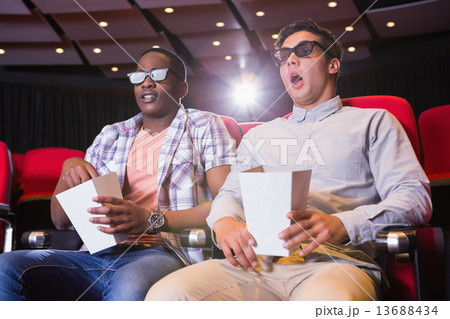 Astonished young friends watching 3d film Astonished young friends watching 3d film 13688434