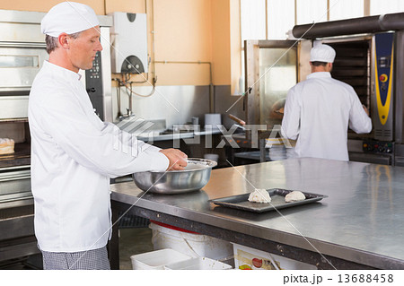 Baker making dough in mixing bowl Baker making dough in mixing bowl 13688458