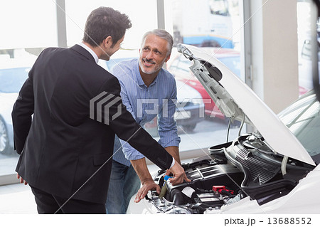 Two men looking at a car engine 13688552