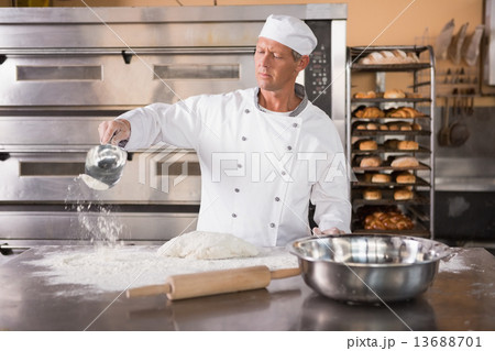 Baker working with scoop and dough Baker working with scoop and dough 13688701