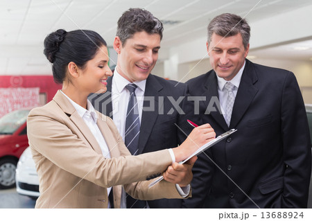 Smiling business team working together on clipboard Smiling business team working together on clipboard 13688924
