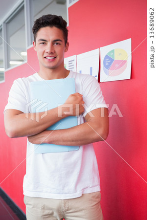Smiling student holding notebook Smiling student holding notebook 13689062