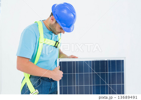 Construction worker examining solar panel 13689491