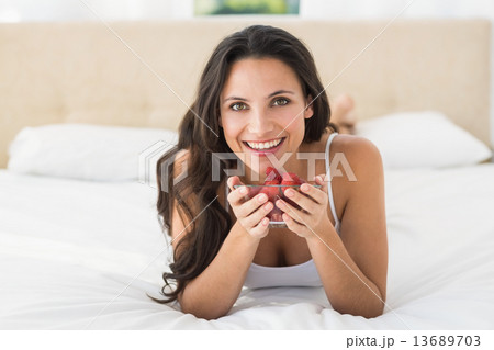 Happy brunette with bowl of strawberries 13689703
