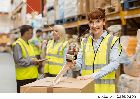 Smiling warehouse workers preparing a shipment 13690208