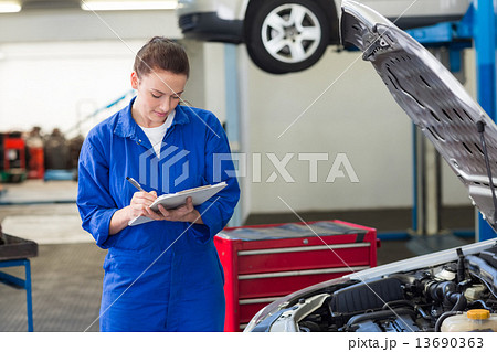 Mechanic examining under hood of car Mechanic examining under hood of car 13690363