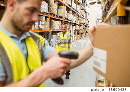 Warehouse worker scanning barcode on box 13690423