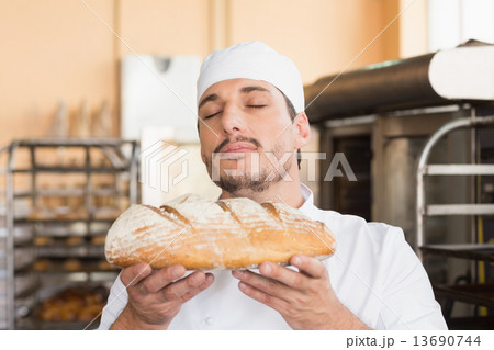 Baker smelling freshly baked loaf 13690744