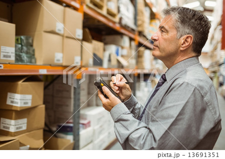 Focused male manager using handheld Focused male manager using handheld 13691351