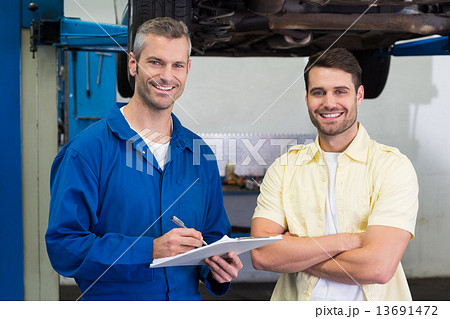 Customer and mechanic smiling at camera Customer and mechanic smiling at camera 13691472