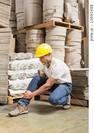 Worker with sprained ankle on the floor 13691488