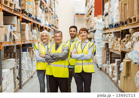 Smiling warehouse team with arms crossed Smiling warehouse team with arms crossed 13691513