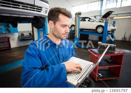 Mechanic using a laptop to work Mechanic using a laptop to work 13691797
