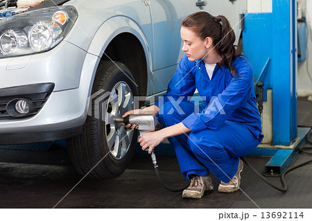 Mechanic adjusting the tire wheel Mechanic adjusting the tire wheel 13692114