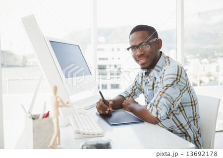 Smiling businessman using digitizer at desk 13692178