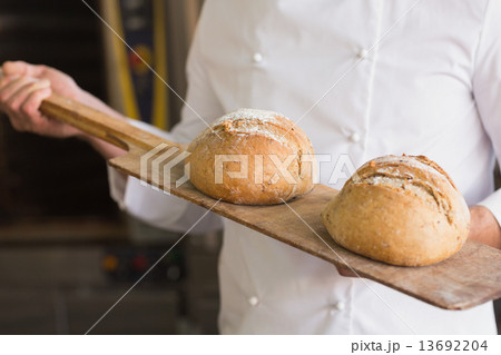 Baker showing tray of fresh bread 13692204