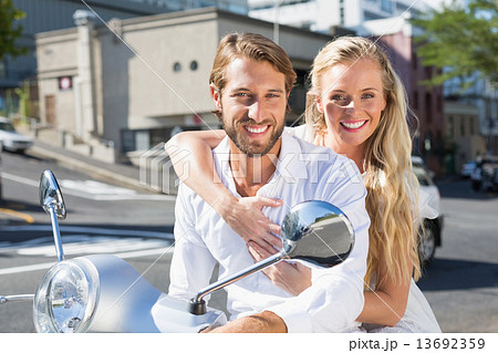 Attractive couple riding a scooter 13692359