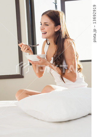 Smiling pretty brunette having breakfast in bed Smiling pretty brunette having breakfast in bed 13692919