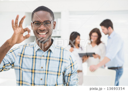 Positive businessman making okay gesture Positive businessman making okay gesture 13693354