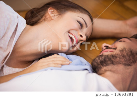 Smiling couple lying on the floor Smiling couple lying on the floor 13693891