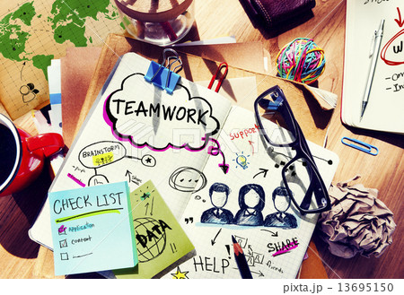Desk with Tools and a Notebook with Ideas About Teamwork 13695150