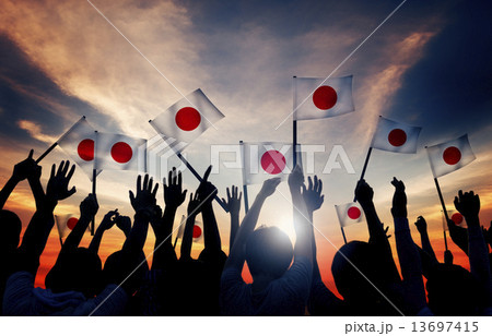 Silhouettes of People Holding the Flag of Japan 13697415