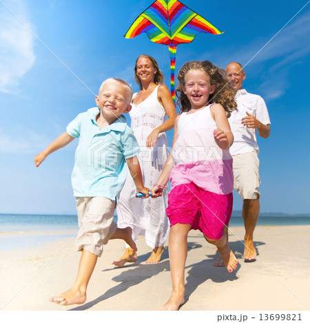 Family running with kite on beach 13699821