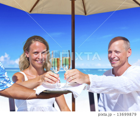Woman and Man Having Champagne by the Beach 13699879