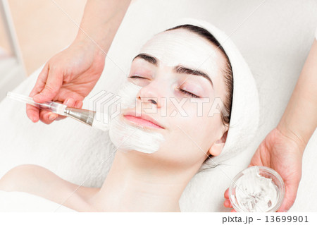 Young woman facial mask applying in beauty parlour 13699901