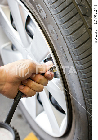 Man's hand checking tyre pressure. 13702244