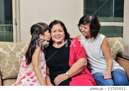young Asian granddaughter giving a kiss to her grandmother to show her affection young Asian granddaughter giving a kiss to her grandmother to show her affection 13705021