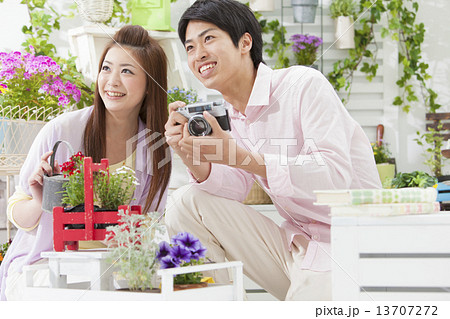 じょうろを持っている女性とカメラを持っている男性 13707272