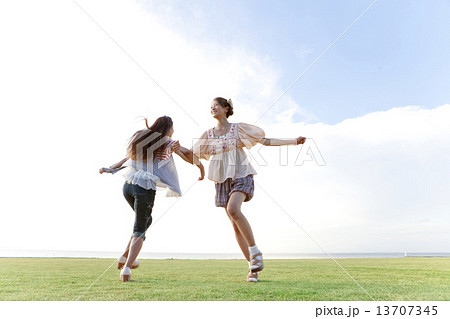 腕を組んで遊ぶ女性2人の写真素材