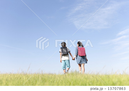 手をつないで歩く小学生2人 13707863
