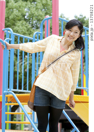 公園で遊んでいる若い女性 13708221