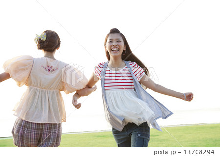 腕を組んで遊ぶ女性2人 13708294