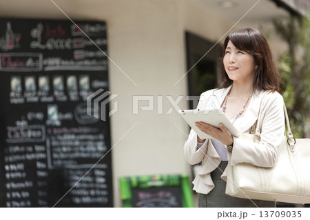 タブレットPCを操作している中高年女性 13709035