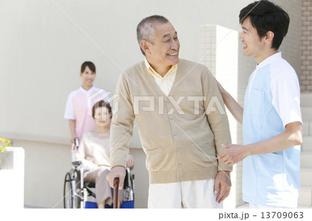 介護士と杖をつく中高年男性 13709063