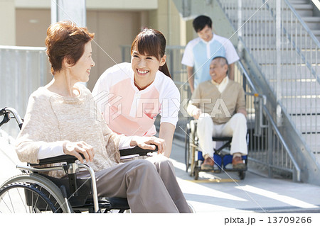 介護士と車いすに乗った中高年女性 13709266