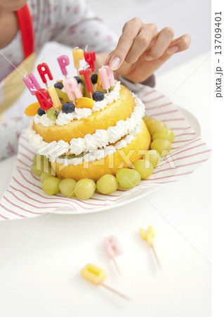 ケーキにろうそくを挿す女性の手 ケーキにろうそくを挿す女性の手 13709401